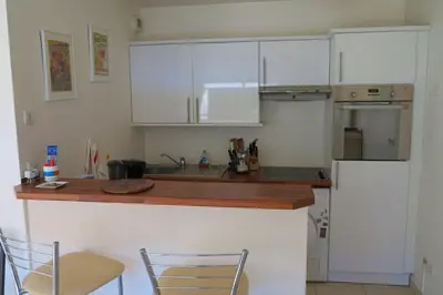 a kitchen with white cabinets and a wooden counter top at Viva Riviera -14 Avenue Isola Bella in Cannes