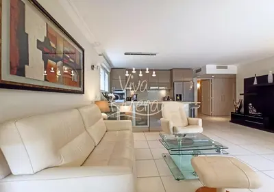 a living room with a white couch and a glass table at Viva Riviera -14 Avenue Isola Bella in Cannes