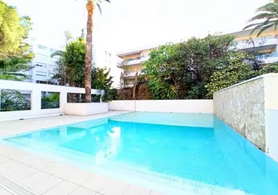 a swimming pool in a villa with a palm tree at Viva Riviera -14 Avenue Isola Bella in Cannes