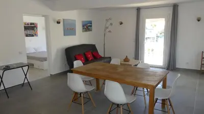 a living room with a table and chairs and a bed at Bas de villa prestations haut de gamme in Vallauris