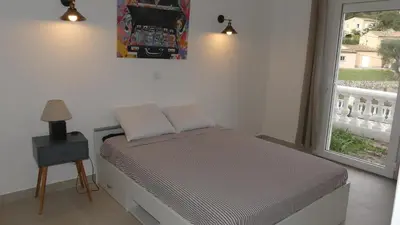a small bed in a room with a window at Bas de villa prestations haut de gamme in Vallauris