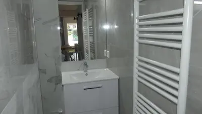 a white bathroom with a sink and a mirror at Bas de villa prestations haut de gamme in Vallauris