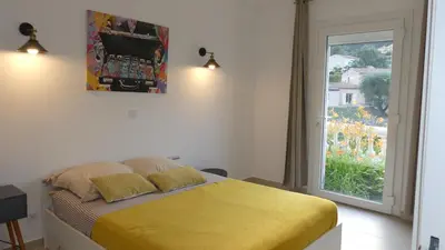 a bedroom with a yellow bed and a window at Bas de villa prestations haut de gamme in Vallauris