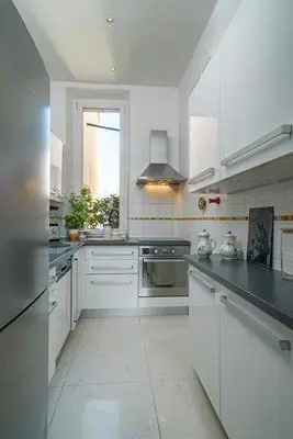 a large kitchen with white cabinets and a window at Good sleeping in Cannes