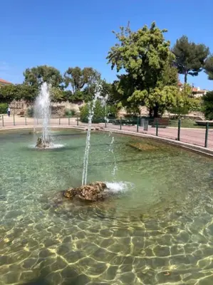 a fountain in a pool of water in a park at Cannes, charmant 3 pièces proche centre et plages in Cannes