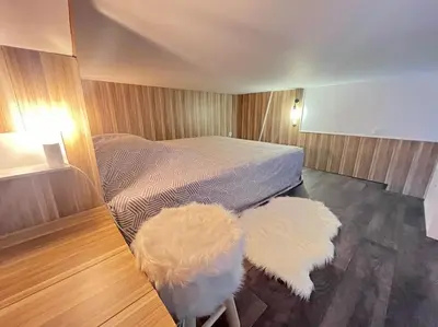 a bedroom with a bed and two white tufted chairs at Cannes, Loft 6 couchages proche centre et plages in Cannes