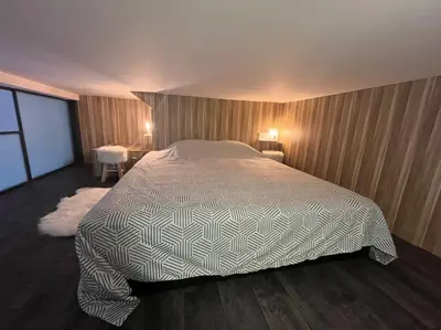 a bedroom with a large bed and a wooden floor at Cannes, Loft 6 couchages proche centre et plages in Cannes