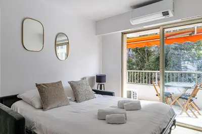 a bedroom with a large bed and a balcony at CANNES 2 P avec terrasse PROCHE Hôtel Martinez in Cannes