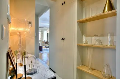 a room with a table with a lamp and a hallway at FAR5 - 3 chambres à deux pas de la rue d'Antibes in Cannes