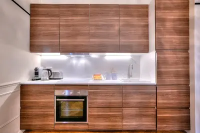 a kitchen with wooden cabinets and a sink at FAR5 - 3 chambres à deux pas de la rue d'Antibes in Cannes
