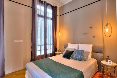 a bedroom with a bed and a large window at FAR5 - 3 chambres à deux pas de la rue d'Antibes in Cannes