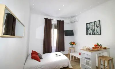 a bedroom with a bed and a desk and a window at Le Borniol ! Idéal ! Congrès! Central! lumineux! in Cannes