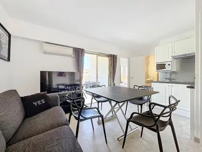 a living room with a couch and a table and chairs at 2P Between Croisette Beaches and Antibes Street in Cannes