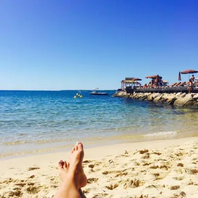 a woman laying on a beach with her feet in the sand at 2P Between Croisette Beaches and Antibes Street in Cannes