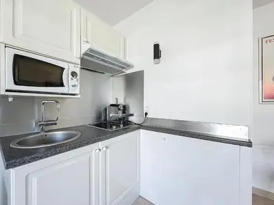 a white kitchen with a sink and a microwave at 2P Between Croisette Beaches and Antibes Street in Cannes