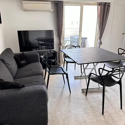 a living room with a couch and a table and chairs at 2P Between Croisette Beaches and Antibes Street in Cannes