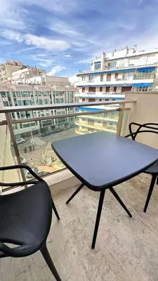 a table and chairs on a balcony with a view of a building at 2P Between Croisette Beaches and Antibes Street in Cannes