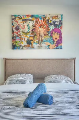 a blanket on a bed with a painting on the wall at Coco - Spacieux - Luxueux - VCA in Cannes