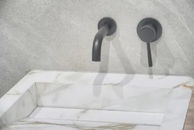 a marble sink with two handles on a wall at Coco - Spacieux - Luxueux - VCA in Cannes