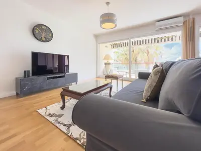 a living room with a couch and a tv at Le Montfleury by Winsome Destination in Cannes