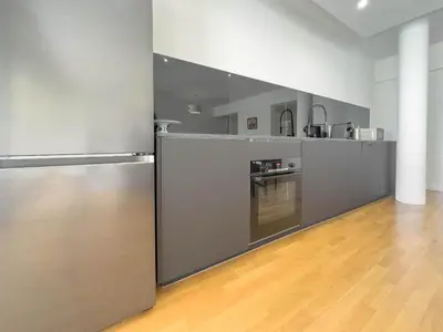 a kitchen with stainless steel appliances and a wooden floor at Le Montfleury by Winsome Destination in Cannes