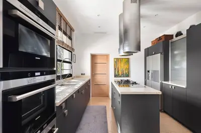 a large kitchen with black cabinets and a stove top oven at Villa avec piscine à Cannes 7 bedrooms in Le Cannet