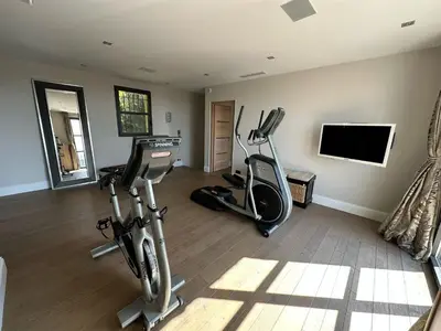 a gym with two exercise bikes and a flat screen tv at Villa avec piscine à Cannes 7 bedrooms in Le Cannet