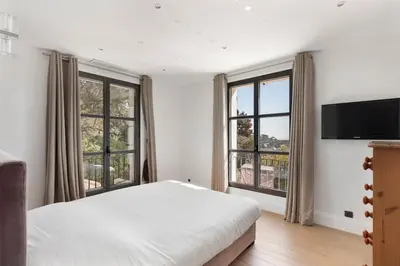 a bedroom with a bed and two large windows at Villa avec piscine à Cannes 7 bedrooms in Le Cannet