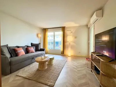a living room with a couch and a television at Le Montébello By SCLS Locations in Cannes