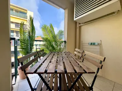 a wooden table with two benches on a balcony at Le Montébello By SCLS Locations in Cannes