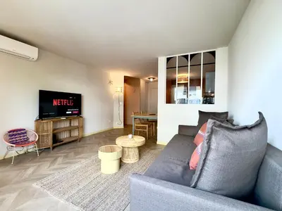a living room with a couch and a tv at Le Montébello By SCLS Locations in Cannes