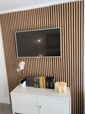 a television on a wall with a white table with candles at Charmant studio Croisette in Cannes