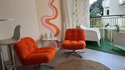 a living room with two orange chairs and a table at Charmant studio Croisette in Cannes