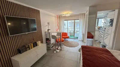 a living room with a flat screen tv on a wall at Charmant studio Croisette in Cannes