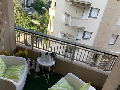 a balcony with a couch and a table and a building at Charmant studio Croisette in Cannes