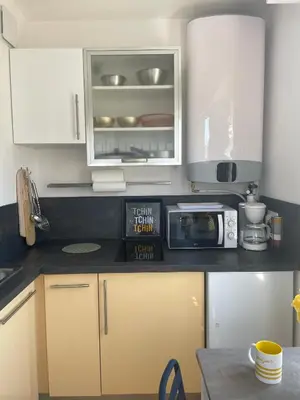 a kitchen with white cabinets and a microwave at Studio Stella in Cannes
