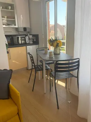 a dining room table with two chairs and a kitchen at Studio Stella in Cannes