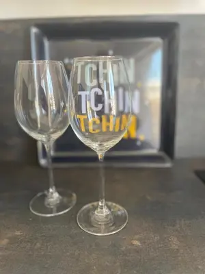 two wine glasses sitting on a table with a fireplace at Studio Stella in Cannes
