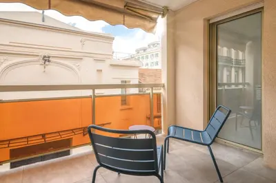 a balcony with two chairs and a window at REF 1967 - Cannes Center - Apartment for rent in Cannes