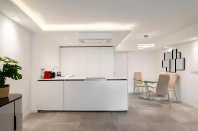 a kitchen with white cabinets and a table at REF 1967 - Cannes Center - Apartment for rent in Cannes