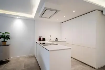 a kitchen with white cabinets and a skylight at REF 1967 - Cannes Center - Apartment for rent in Cannes