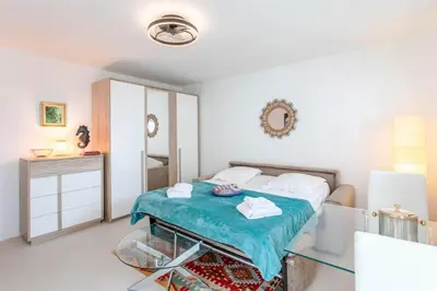 a bedroom with a bed and a mirror at L'Hippocampe du Palm Beach in Cannes