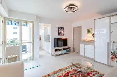 a living room with a glass table and a television at L'Hippocampe du Palm Beach in Cannes