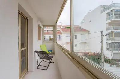 a green chair sitting on a balcony with a window at L'Hippocampe du Palm Beach in Cannes