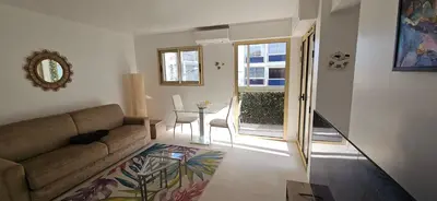 a living room with a couch and a table at L'Hippocampe du Palm Beach in Cannes