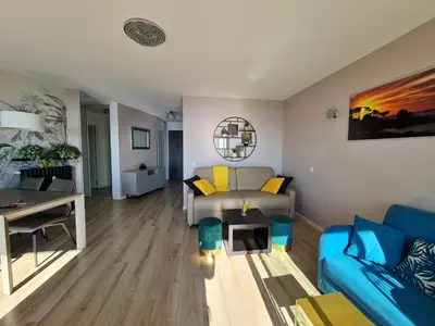 a living room with a blue couch and a table at Western Cannes - Panoramic View in Cannes