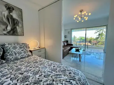 a bedroom with a bed and a view of a pool at Grande terrasse vue dégagée mer en Basse Californie in Cannes