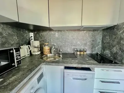 a kitchen counter with a sink and a microwave at Grande terrasse vue dégagée mer en Basse Californie in Cannes