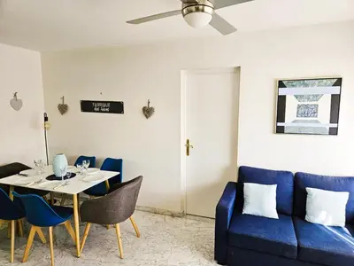 a dining room with a blue couch and a table at Le 66 Carnot in Cannes