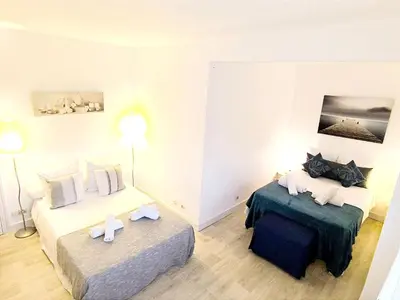 a hotel room with two beds and two tables at Le 66 Carnot in Cannes